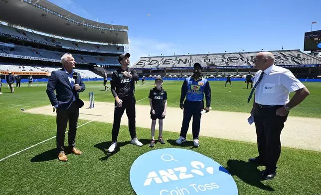 Commentator Mark Richardson, from left, Captain of New Zealand Mitchell Santner, ANZ coin toss kid John Green, Captain of Sri Lanka Charith Asalanka and ICC match referee Jeff Crowe hold a coin toss during the 3rd one day international cricket match between New Zealand and Sri Lanka at Eden Park in Auckland, New Zealand, Saturday, Jan. 11, 2025. (Andrew Cornaga/Photosport via AP)