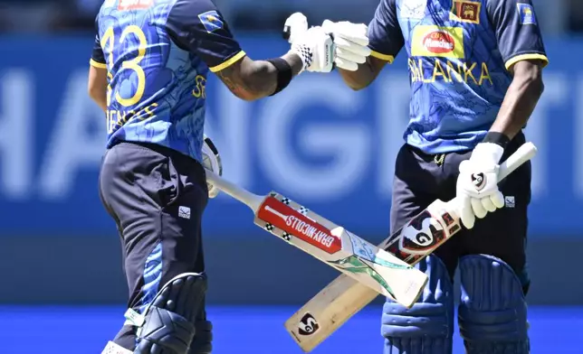 Sri Lanka's Kusal Mendis, left, and Kamindu Mendis make a fist-bump during the 3rd one day international cricket match between New Zealand and Sri Lanka at Eden Park in Auckland, New Zealand, Saturday, Jan. 11, 2025. (Andrew Cornaga/Photosport via AP)