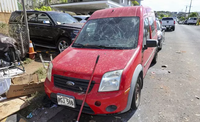 A damaged vehicle is seen near the home where a New Year's Eve fireworks explosion killed and injured people, Wednesday, Jan. 1, 2025, in Honolulu. (AP Photo/Marco Garcia)