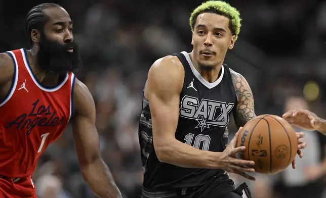 San Antonio Spurs' Jeremy Sochan (10) drives against Los Angeles Clippers' James Harden, left, during the first half of an NBA basketball game, Tuesday, Dec. 31, 2024, in San Antonio. (AP Photo/Darren Abate)