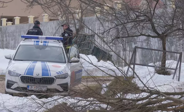 Police officers stand guard at the home of a gunman after a shooting incident, in Cetinje, 36 kilometers (22 miles) west of Podogrica, Montenegro, Thursday, Jan. 2, 2025. (AP Photo/Risto Bozovic)