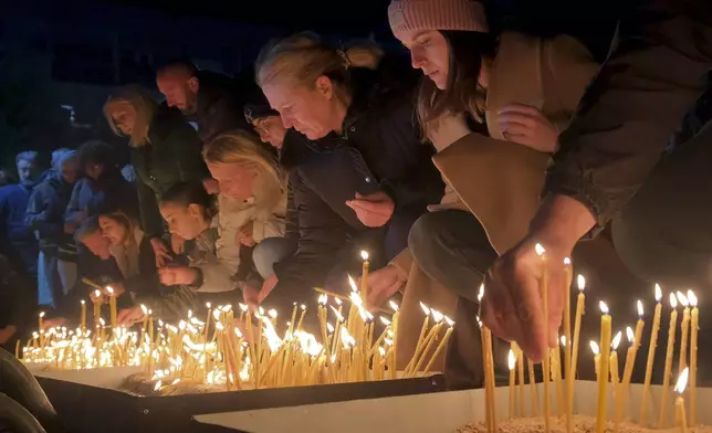 People light candles for the victims of the yesterday's shooting rampage in Cetinje, in Podogrica, Montenegro, Thursday, Jan. 2, 2025. (AP Photo/Risto Bozovic)