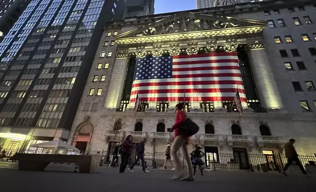 FILE - People pass the New York Stock Exchange on Nov. 5, 2024, in New York. (AP Photo/Peter Morgan, File)