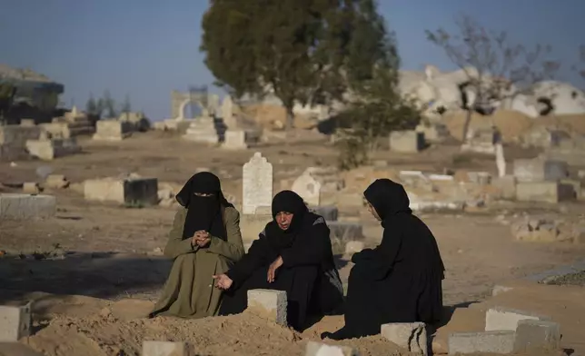 Fatma Abu Awad and her daughter Malak pray in a graveyard where their relatives who were killed by an Israeli airstrike are buried, in Khan Younis, Gaza, Thursday, Jan. 9, 2025. (AP Photo/Abdel Kareem Hana)