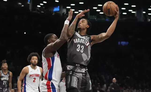 Brooklyn Nets' Nic Claxton (33) shoots over Detroit Pistons' Jalen Duren (0) during the first half of an NBA basketball game, Wednesday, Jan. 8, 2025, in New York. (AP Photo/Frank Franklin II)