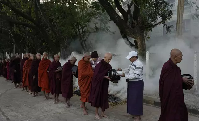 Buddhist monks line up to collect their morning alms from Buddhist devotees Saturday, Feb. 1, 2025, in Naypyitaw, Myanmar. (AP Photo/Aung Shine Oo)