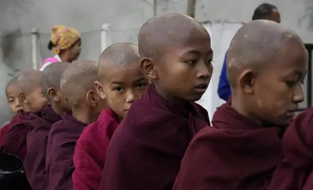 Buddhist novice monks line up to collect their morning alms from Buddhist devotees Saturday, Feb. 1, 2025, in Naypyitaw, Myanmar. (AP Photo/Aung Shine Oo)