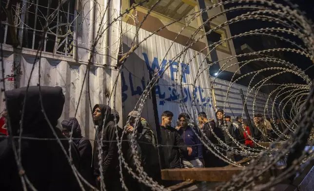 Palestinians wait in line at a World Food Program (WFP) distribution center in Gaza City's Jabalya refugee camp, Thursday, Feb. 6, 2025. (AP Photo/Jehad Alshrafi)
