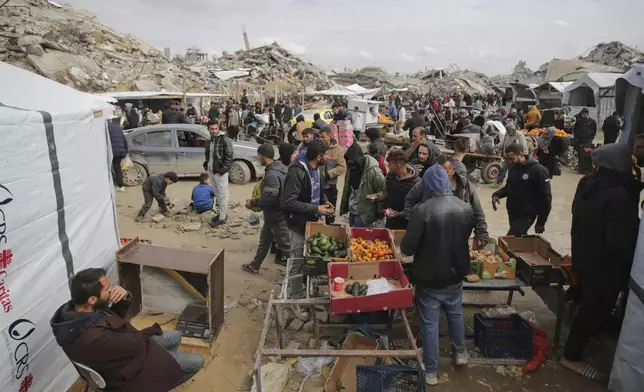 Palestinians purchase goods at a makeshift market set up amid widespread destruction caused by the Israeli military's ground and air offensive in Gaza City's Jabaliya refugee camp, Friday, Feb. 7, 2025. (AP Photo/Jehad Alshrafi)