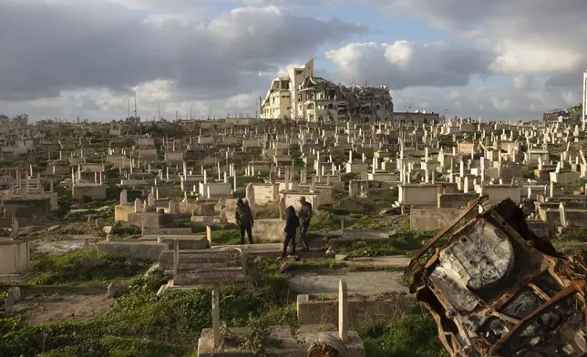 Palestinians visit the grave of a relative at the cemetery in Gaza City Thursday, Feb. 6, 2025, after collecting donated food. (AP Photo/Jehad Alshrafi)