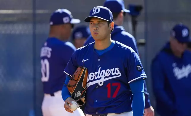 Los Angeles Dodgers two-way player Shohei Ohtani (17) works out during spring training baseball practice, Saturday, Feb. 15, 2025, in Phoenix. (AP Photo/Ashley Landis)