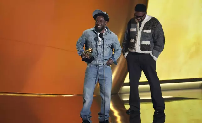 Kendrick Lamar, left, accepts the record of the year award for "Not Like Us during the 67th annual Grammy Awards on Sunday, Feb. 2, 2025, in Los Angeles. Mustard looks on from right. (AP Photo/Chris Pizzello)