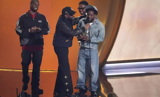Kendrick Lamar, center, accepts the award for song of the year for "Not Like Us" during the 67th annual Grammy Awards on Sunday, Feb. 2, 2025, in Los Angeles. Dave Free, from left, Sounwave, and Mustard look on from rear of the stage.(AP Photo/Chris Pizzello)