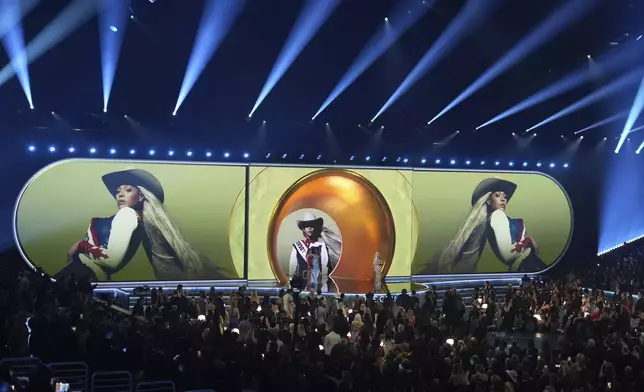 Beyonce accepts the award for best country album for "COWBOY CARTER" during the 67th annual Grammy Awards on Sunday, Feb. 2, 2025, in Los Angeles. Taylor Swift looks on from left. (AP Photo/Chris Pizzello)