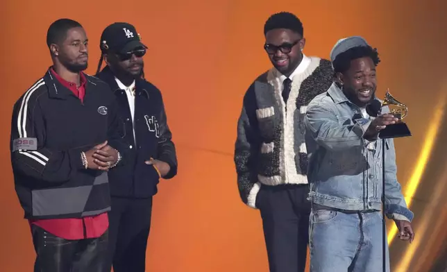 Kendrick Lamar, center, accepts the award for song of the year for "Not Like Us" during the 67th annual Grammy Awards on Sunday, Feb. 2, 2025, in Los Angeles. Dave Free, from left, Sounwave, and Mustard look on from rear of the stage.(AP Photo/Chris Pizzello)