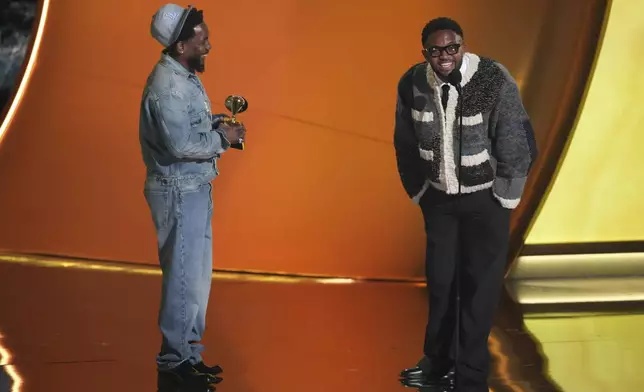 Kendrick Lamar, left, accepts the record of the year award for "Not Like Us during the 67th annual Grammy Awards on Sunday, Feb. 2, 2025, in Los Angeles. Mustard looks on from right. (AP Photo/Chris Pizzello)