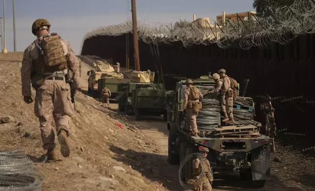 U.S. Marines install barbed wire along the border fence Friday, Jan. 31, 2025, in San Diego. (AP Photo/Jae C. Hong)