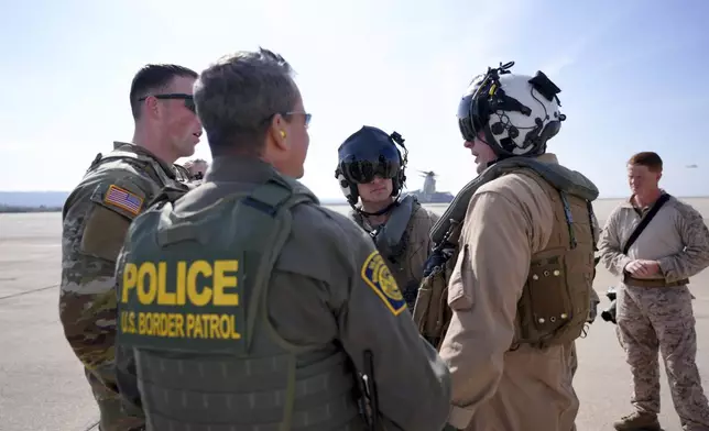 U.S. Marine pilots and U.S. Border Patrol agents interact at the Naval Outlying Landing Field Friday, Jan. 31, 2025, in Imperial Beach, Calif. (AP Photo/Jae C. Hong)