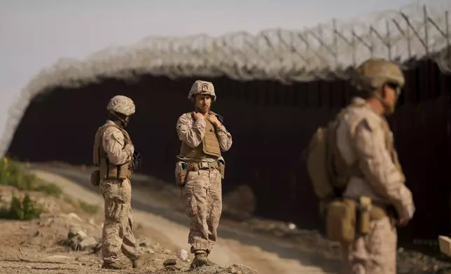 U.S. Marines install barbed wire along the border fence Friday, Jan. 31, 2025, in San Diego. (AP Photo/Jae C. Hong)
