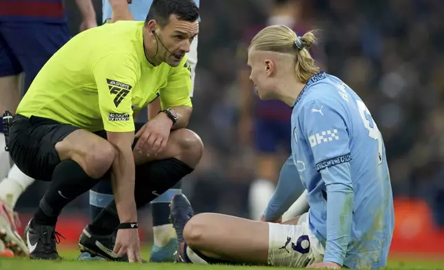 Referee Andy Madley checks on Manchester City's Erling Haaland after he injured himself during the English Premier League soccer match between Manchester City and Newcastle United at Etihad stadium in Manchester, England, Saturday, Feb. 15, 2025. (AP Photo/Ian Hodgson)