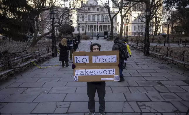 A person holds a sign reading "No Tech Takeover" during a protest outside City Hall, Wednesday, Feb. 5, 2025, in New York. (AP Photo/Yuki Iwamura)