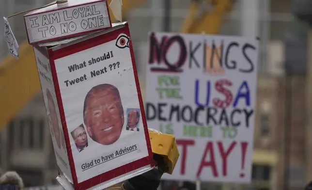 Signs are displayed during a protest outside the Wisconsin Capitol Wednesday, Feb. 5, 2025, in Madison, Wis. (AP Photo/Morry Gash)