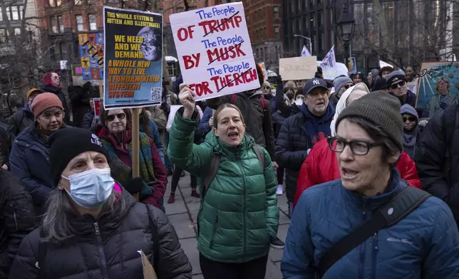 Demonstrators raise signs during a protest outside City Hall, Wednesday, Feb. 5, 2025, in New York. (AP Photo/Yuki Iwamura)
