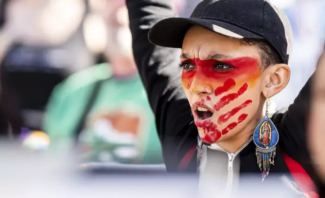 Rissi Ferguson chants while rallying against President Donald Trump outside the California State Capitol on Wednesday, Feb. 5, 2025, in Sacramento, Calif. (AP Photo/Noah Berger)