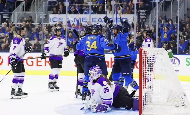 Toronto Sceptres' Natalie Spooner (centre right) celebrates a goal with Hannah Miller (34) as Minnesota Frost goaltender Maddie Rooney (35) lays on the ice during the second period of their PWHL hockey game, in Toronto, Tuesday, Feb. 11, 2025. (Cole Burston/The Canadian Press via AP)