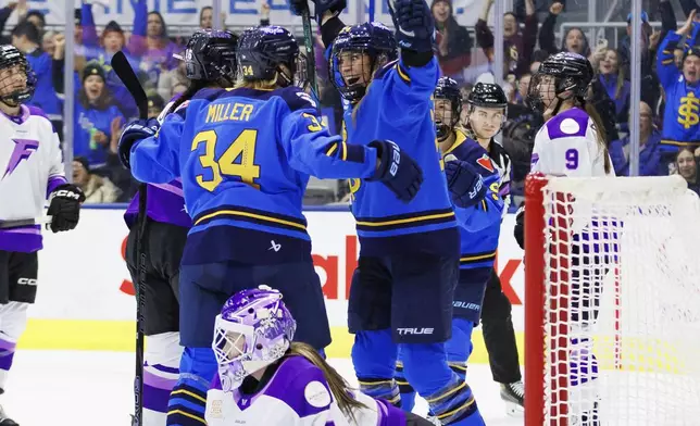 Toronto Sceptres' Natalie Spooner (centre right) celebrates a goal with Hannah Miller (34) as Minnesota Frost goaltender Maddie Rooney (35) lays on the ice during the second period of their PWHL hockey game, in Toronto, Tuesday, Feb. 11, 2025. (Cole Burston/The Canadian Press via AP)