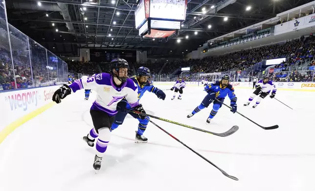 Minnesota Frost's Grace Zumwinkle (13) and Toronto Sceptres' Savannah Harmon race for the puck during the first period of a PWHL hockey game in Toronto, Tuesday, Feb. 11, 2025. (Cole Burston/The Canadian Press via AP)