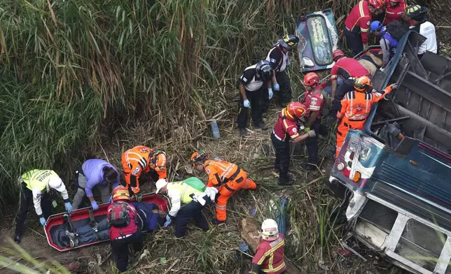 Firefighters work at the scene of a fatal bus crash after it fell from a bridge on the outskirts of Guatemala City, Monday, Feb. 10, 2025. (AP Photo/Moises Castillo)