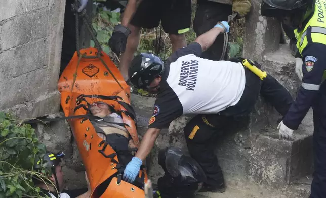 Firefighters lift a stretcher carrying a victim after a fatal bus crash after it fell from a bridge on the outskirts of Guatemala City, Monday, Feb. 10, 2025. (AP Photo/Moises Castillo)