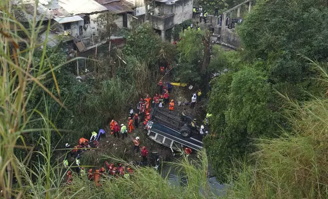 Firefighters work the scene of a fatal bus crash after it fell from a bridge on the outskirts of Guatemala City, Monday, Feb. 10, 2025. (AP Photo/Moises Castillo)