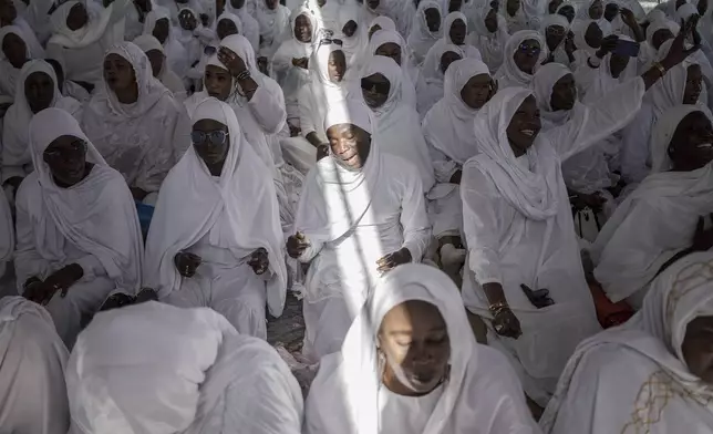 Dressed in white robes to symbolize purity and equality before God, followers from the Layene brotherhood commemorate the first public appearance of their founder Seydina Limamou Laye in 1884 at Yoff's beachside mosque in Dakar, Senegal, Friday, Jan. 31, 2025. (AP Photo/Annika Hammerschlag)