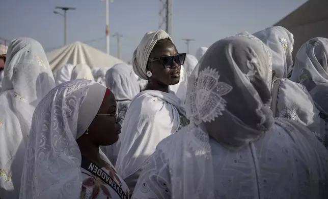 Dressed in white robes to symbolize purity and equality before God, followers from the Layene brotherhood commemorate the first public appearance of their founder Seydina Limamou Laye in 1884 at Yoff's beachside mosque in Dakar, Senegal, Friday, Jan. 31, 2025. (AP Photo/Annika Hammerschlag)