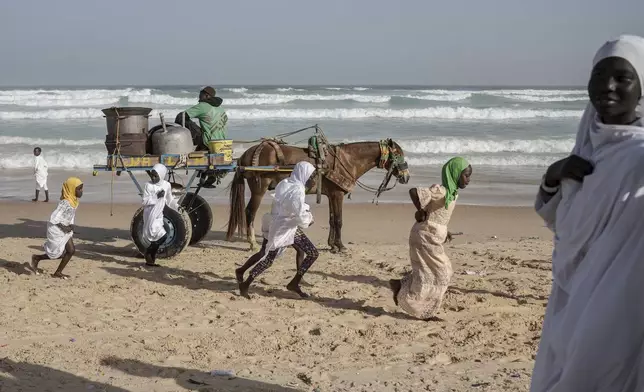 Dressed in white robes to symbolize purity and equality before God, followers from the Layene brotherhood commemorate the first public appearance of their founder Seydina Limamou Laye in 1884 at Yoff's beachside mosque in Dakar, Senegal, Friday, Jan. 31, 2025. (AP Photo/Annika Hammerschlag)