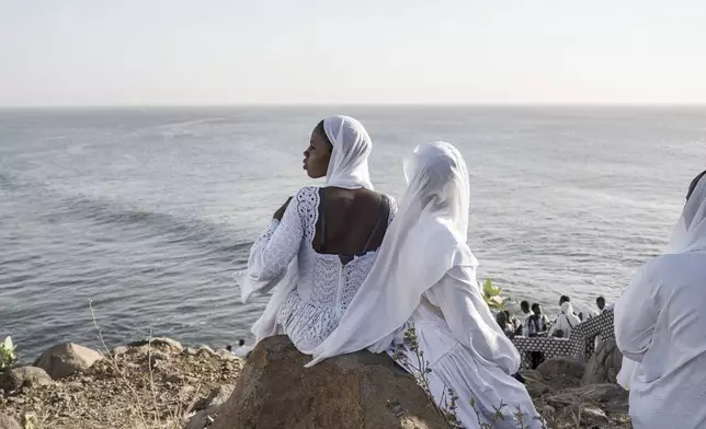 Dressed in white robes to symbolize purity and equality before God, followers from the Layene brotherhood gather at a sacred grotto where they believe their prophet received divine inspiration, in Dakar, Senegal, Thursday, Jan. 30, 2025. (AP Photo/Annika Hammerschlag)