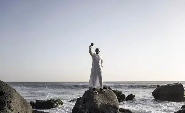 Dressed in white robes to symbolize purity and equality before God, followers from the Layene brotherhood gather at a sacred grotto where they believe their prophet received divine inspiration, in Dakar, Senegal, Thursday, Jan. 30, 2025. (AP Photo/Annika Hammerschlag)