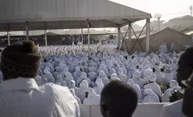 Dressed in white robes to symbolize purity and equality before God, followers from the Layene brotherhood commemorate the first public appearance of their founder Seydina Limamou Laye in 1884 at Yoff's beachside mosque in Dakar, Senegal, Friday, Jan. 31, 2025. (AP Photo/Annika Hammerschlag)