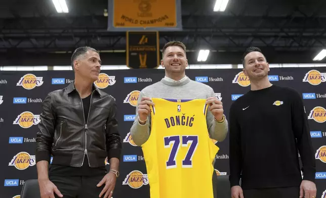 From left to right, Los Angeles Lakers general manager Rob Pelinka, Luka Doncic, and head coach JJ Redick pose for photos during an introductory NBA basketball press conference Tuesday, Feb. 4, 2025, in El Segundo, Calif. (AP Photo/Jae C. Hong)