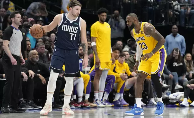 FILE - Dallas Mavericks guard Luka Doncic (77) dribbles against Los Angeles Lakers forward LeBron James (23) during the second half of an NBA basketball game in Dallas, Dec. 12, 2023. (AP Photo/LM Otero, File)