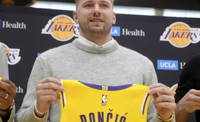 Los Angeles Lakers' Luka Doncic poses for photos with his new jersey during an introductory NBA basketball press conference Tuesday, Feb. 4, 2025, in El Segundo, Calif. (AP Photo/Jae C. Hong)