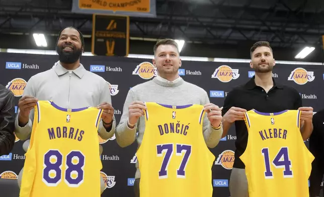 From left to right, Los Angeles Lakers' Markieff Morris, Luka Doncic and Maxi Kleber pose with their new jerseys during an introductory NBA basketball press conference Tuesday, Feb. 4, 2025, in El Segundo, Calif. (AP Photo/Jae C. Hong)