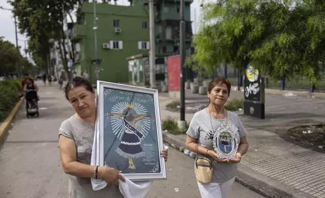 Faithful Maria Eugenia Escalante, right, and Felicia Rios carry the image of Jesus del Maiz, venerated in Bolivia, after a Mass in the Carlos Mugica neighborhood of Buenos Aires, Argentina, Sunday, Feb. 23, 2025. (AP Photo/Rodrigo Abd)