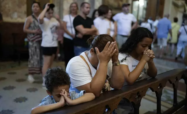 Faithful pray for Pope Francis' health during a Mass at the Cathedral in Buenos Aires, Argentina, Sunday, Feb. 23, 2025. (AP Photo/Natacha Pisarenko)