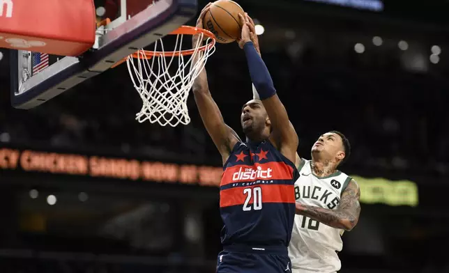 Washington Wizards forward Alex Sarr (20) is fouled by Milwaukee Bucks forward Kyle Kuzma, right, during the first half of an NBA basketball game, Friday, Feb. 21, 2025, in Washington. (AP Photo/Nick Wass)