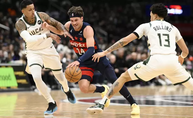 Washington Wizards forward Corey Kispert (24) drives to the basket against Milwaukee Bucks forward Kyle Kuzma, left, and guard Ryan Rollins (13) during the first half of an NBA basketball game, Friday, Feb. 21, 2025, in Washington. (AP Photo/Nick Wass)