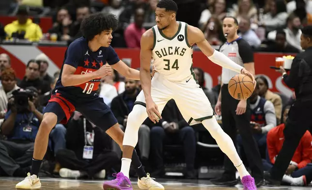 Milwaukee Bucks forward Giannis Antetokounmpo (34) dribbles the ball against Washington Wizards forward Kyshawn George (18) during the first half of an NBA basketball game, Friday, Feb. 21, 2025, in Washington. (AP Photo/Nick Wass)