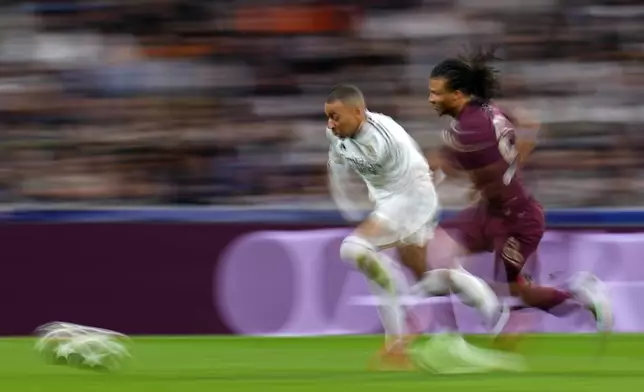 Manchester City's Nathan Ake, right, challenges Real Madrid's Kylian Mbappe during the Champions League playoff second leg soccer match between Real Madrid and Manchester City at the Santiago Bernabeu Stadium in Madrid, Spain, Wednesday, Feb. 19, 2025. (AP Photo/Manu Fernandez)